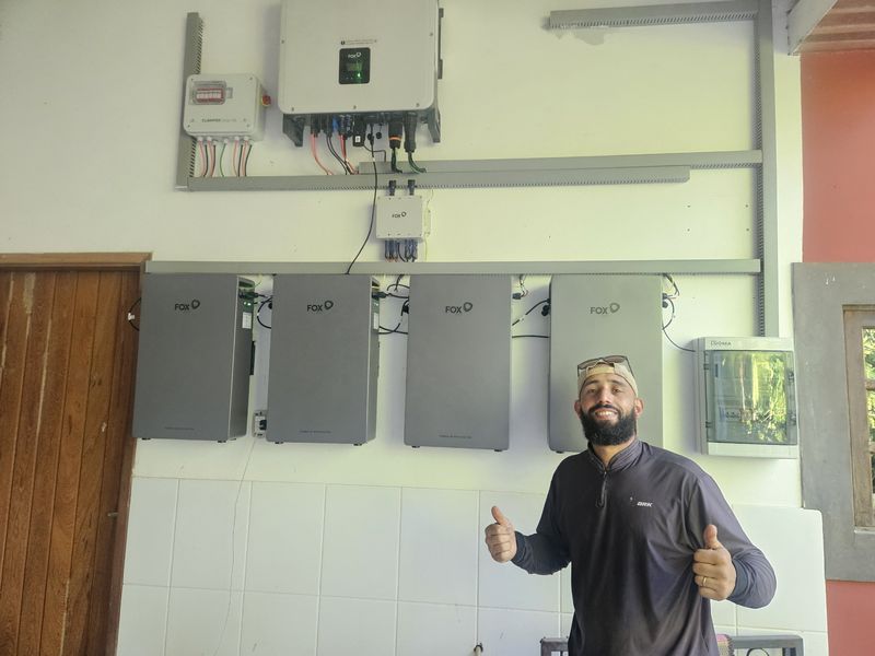 Técnico ao lado de banco com quatro baterias